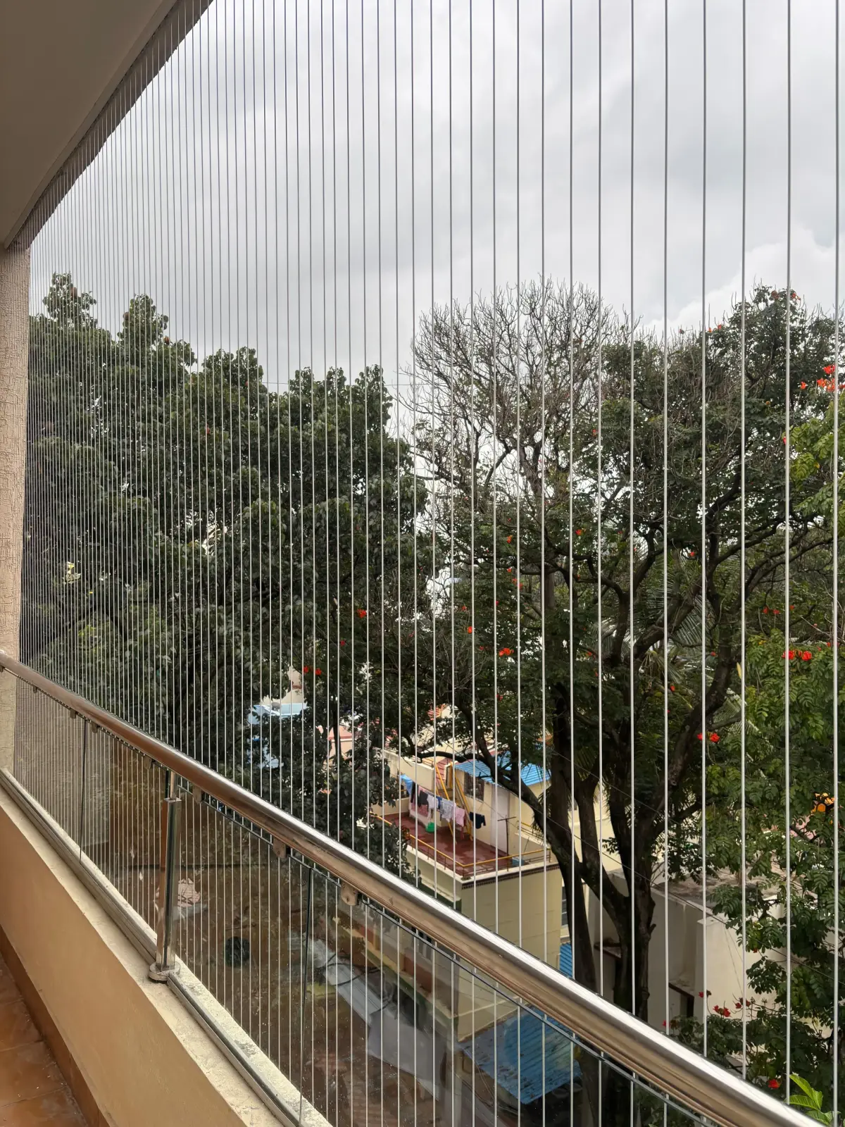Invisible grill cables fitted across a Chennai apartment balcony with the view kept open